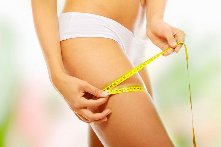 The girl measures the volume of her thigh